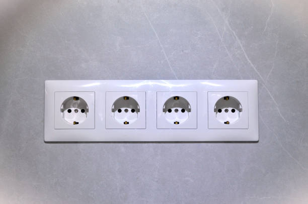 istock block of white electrical sockets, 220, 110 volts, electrics on a gray wall 2203033578