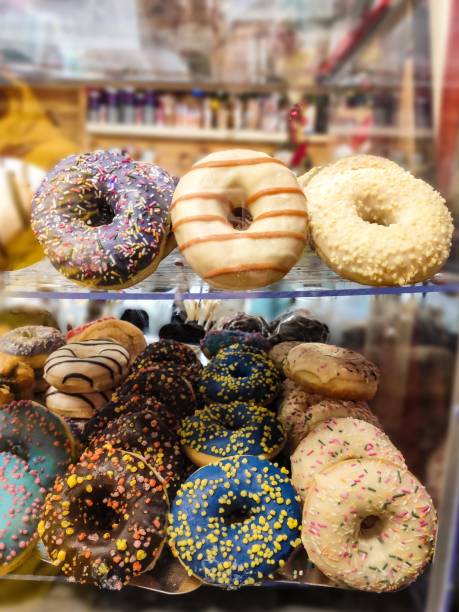 istock donuts on a glass display case in a cafe. glaze, powder, dessert, sugar 2203033626