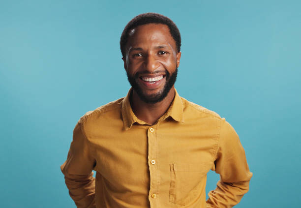 istock Confident, portrait and man with smile, studio and positive mindset for career growth, creative and business. Blue background, mockup space and black person with opportunity, writer or happy 2203034239