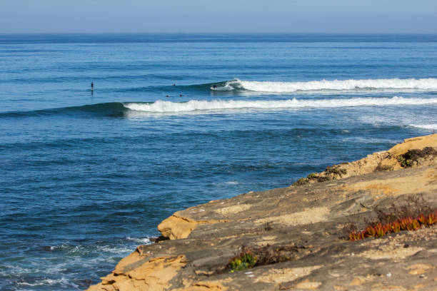 istock Wide angle of surfers in the blue ocean 2203035403