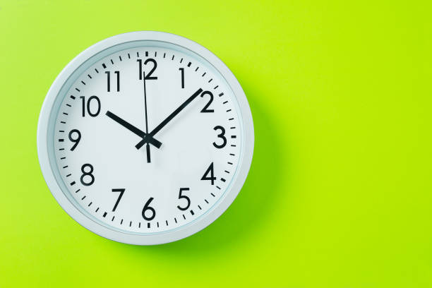istock Round clock with dial on green background. Ecology of time. Ten hours. 2203036058