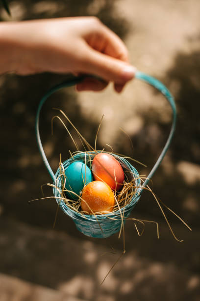 istock Hand holding a basket of colorful eggs 2203036079