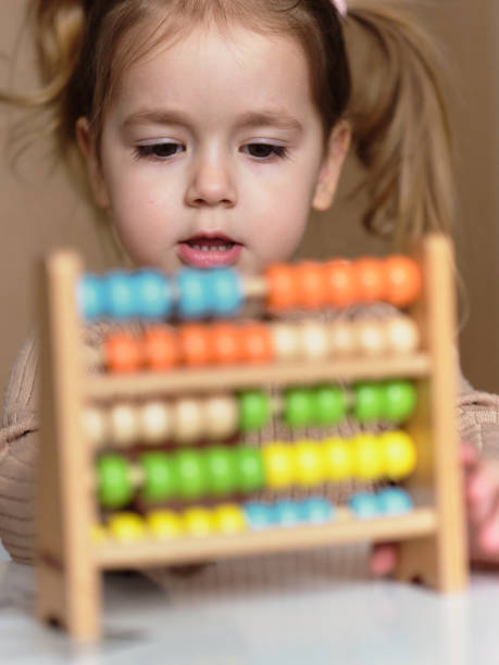 istock Girl is playing with a wooden math toy 2203040375