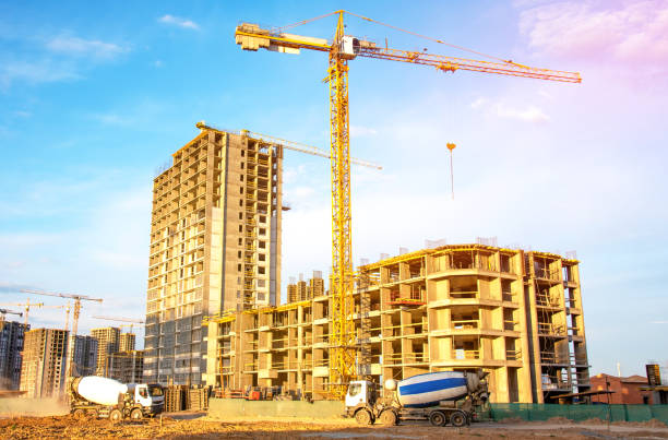 istock Tower crane on building construction. Concrete truck at construction site. 2203041905