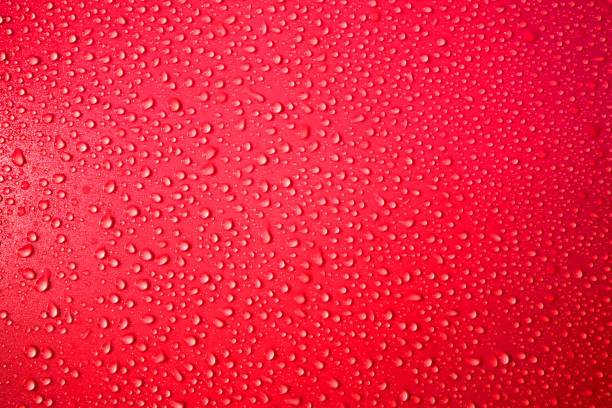 Raindrops background. Close up. Ice cold,  Red surface covered with water drops condensation texture. 