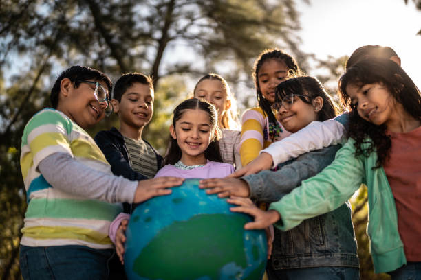 istock Child friends holding a globe outdoors 2203044325