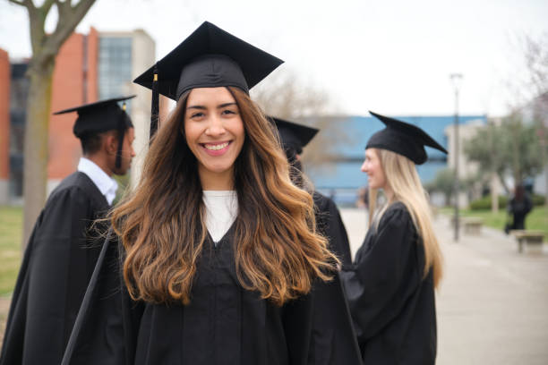 istock Young woman smiling at graduation ceremony with her classmates 2203046853