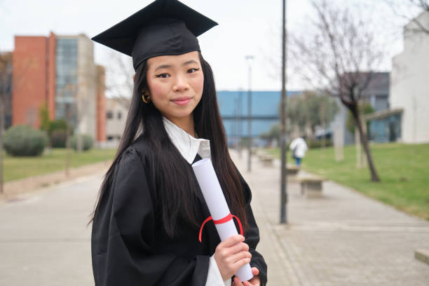 istock Young asian graduate student smiling and holding her diploma 2203049620