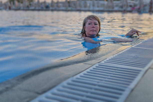 A woman swims in the pool during her vacation