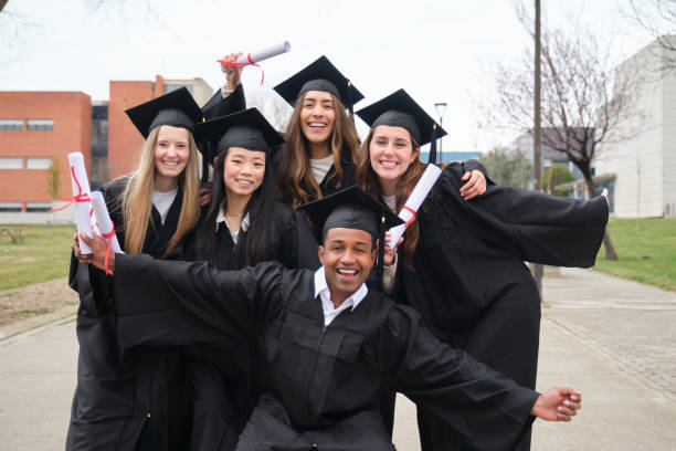 istock Happy multi-ethnic students celebrating graduation holding their diplomas 2203050832