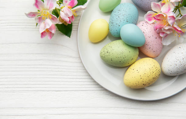 istock Colorful easter eggs with spring flowers resting on white plate 2203051275