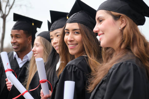 istock Happy multi-ethnic graduates smiling and holding diplomas 2203052306