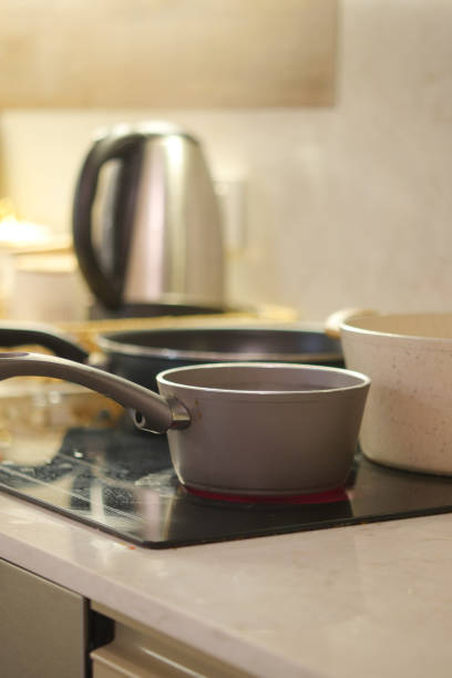 A stylish and modern kitchen showcasing various pots and a kettle elegantly placed on the stove