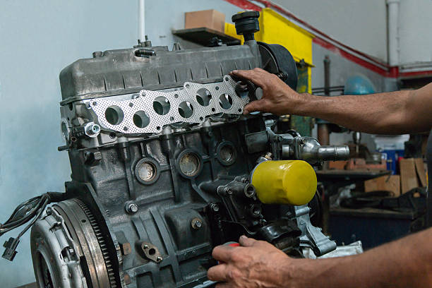 istock Mechanic fitting an engine manifold gasket on a car engine. 2203055787