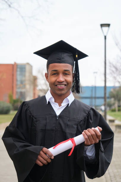 istock Young Graduate Smiling and Holding his Diploma 2203058112