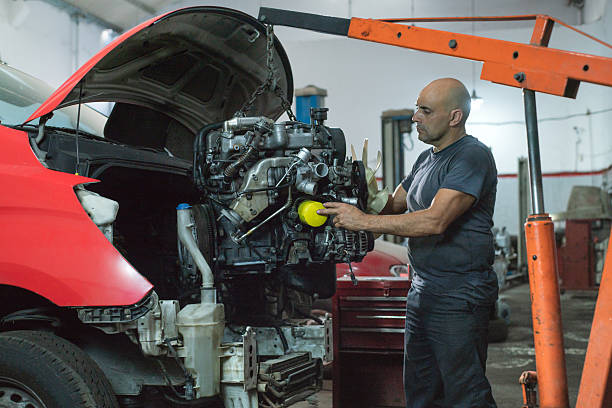 istock Mechanic replacing car engine in garage. 2203061157