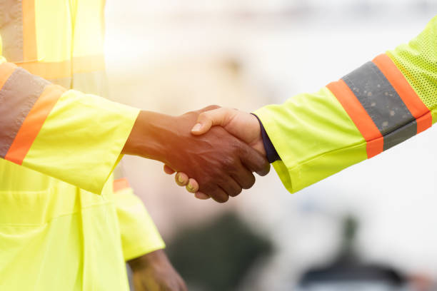 istock Unity and teamwork concept. Male workers standing and hands shake together. Completed finish job. Successful of work 2203062855