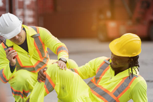 istock Workers accident, helping injured worker, Accident concept. Male worker had accident at container cargo site control loading containers boxes. Health safe of work and safety first concept 2203062870