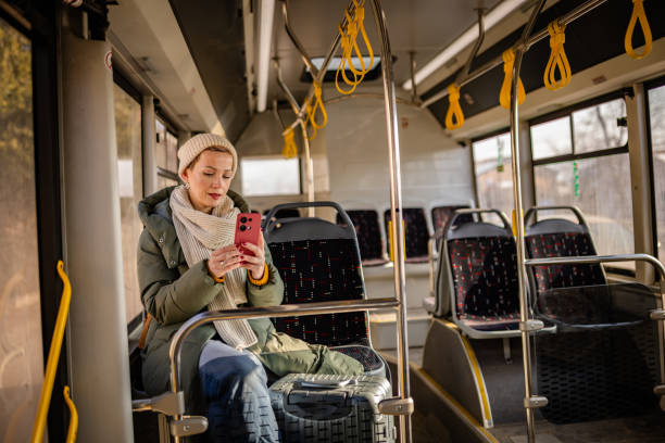 istock Young woman enjoying a leisurely ride on a nearly empty city bus while using her smartphone 2203067704