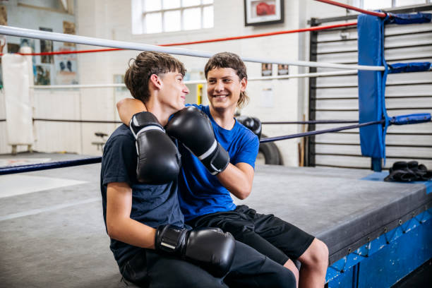 istock Youth Club Portrait: Boxer with glove to opponent’s chin 2203067859