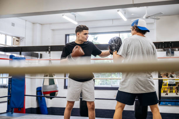 istock Coach and teenage boxer doing focus mitt training 2203068145