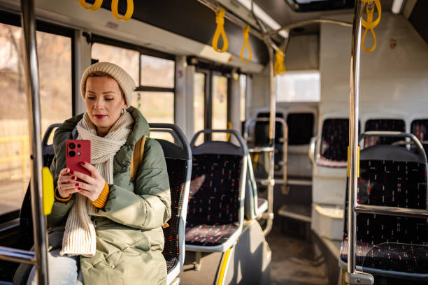 istock Young woman enjoys a cheerful commute on a city bus while using her smartphone during daylight hours 2203070254