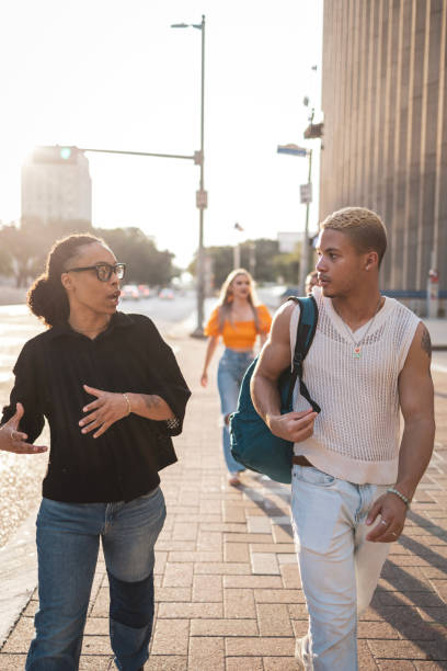 istock People Walking and Conversing on a Sunlit City Street 2203070600