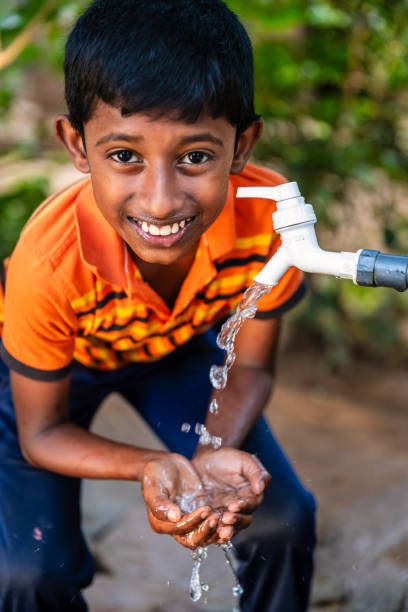 istock Sri Lankan young boy drinking a water, Ceylon 2203071575
