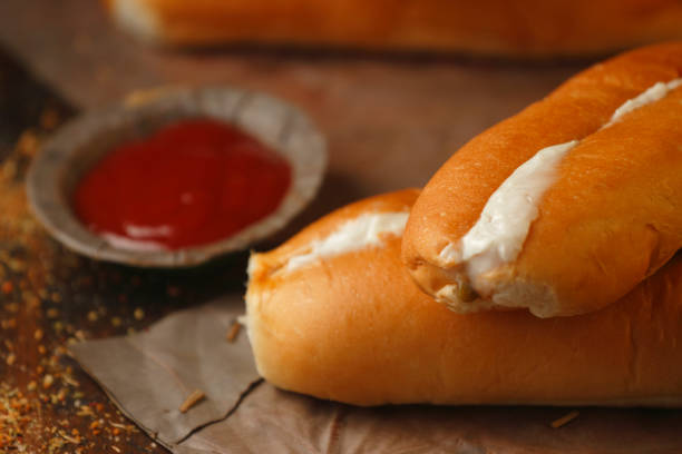 A delicious hot dog wrapped in warm and crispy bread, garnished with spicy and creamy sauce on top