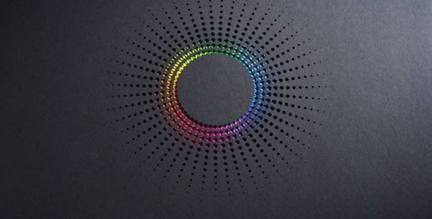 istock Geometric paper cut sunburst design with circular perforations revealing a vibrant rainbow gradient on dark background 2203071829
