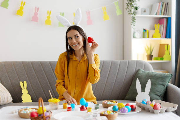 istock Woman painting easter eggs at home 2203071906
