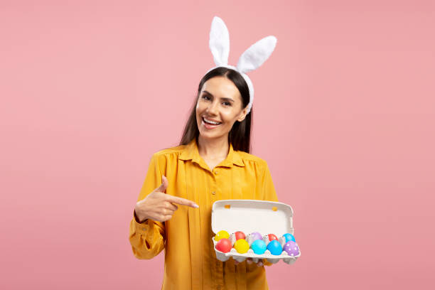 istock Woman pointing at colorful Easter eggs in egg carton 2203072187