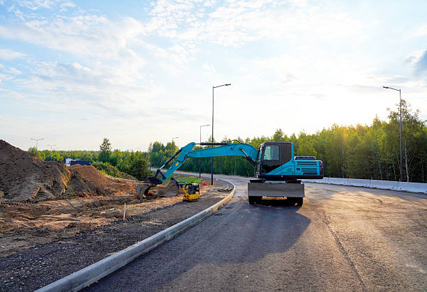 istock Excavator on road construction. Dig ground for installing borders, curbs concrete blocks at road. 2203074839