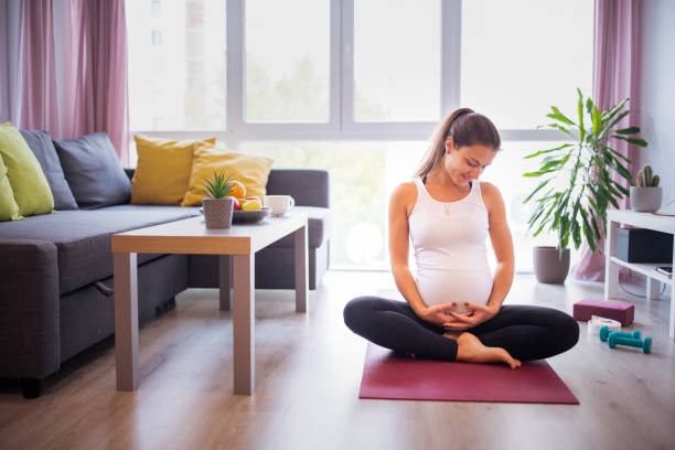istock Pregnant woman exercising at home. 2203077579