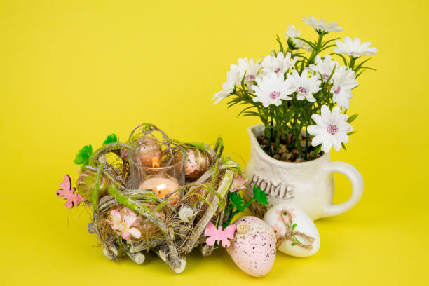 istock Easter eggs and a candle. Easter colorful eggs on a yellow background 2203078778