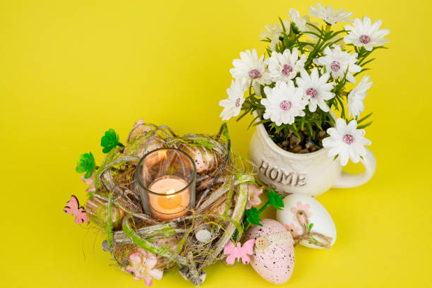 istock Easter eggs and a candle. Easter colorful eggs on a yellow background 2203079876