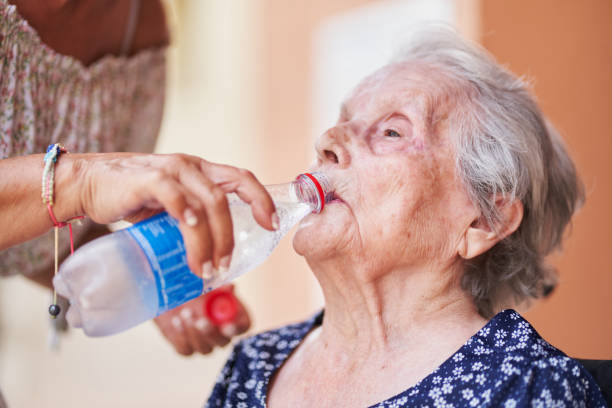 istock Woman helping elderly mother drink water 2203079991