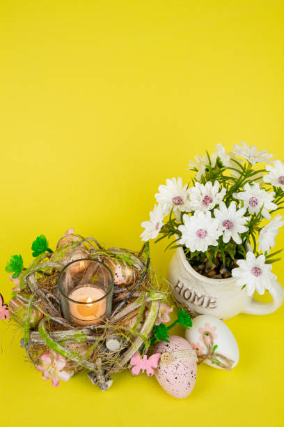 istock Easter eggs and a candle. Easter colorful eggs on a yellow background 2203080935