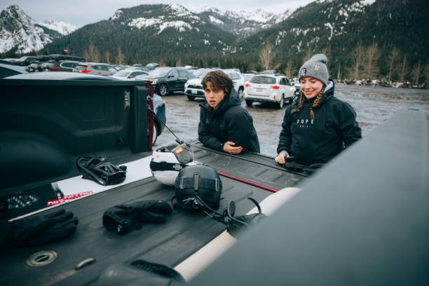 Teens At Mountain Getting Ready to Snowboard