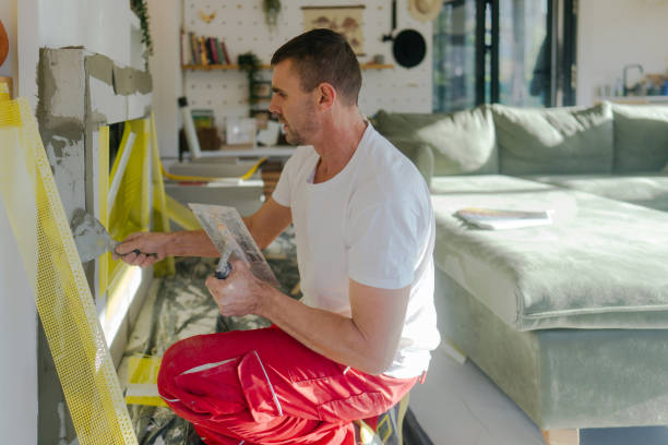 Plastering the fireplace Photo of a manual worker at construction site, plastering a fireplace drywall fireplace stock pictures, royalty-free photos & images
