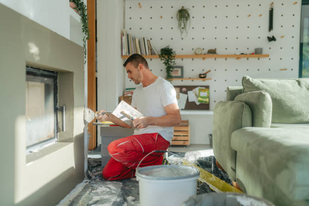 Plastering the fireplace Photo of a manual worker at construction site, plastering a fireplace drywall fireplace stock pictures, royalty-free photos & images
