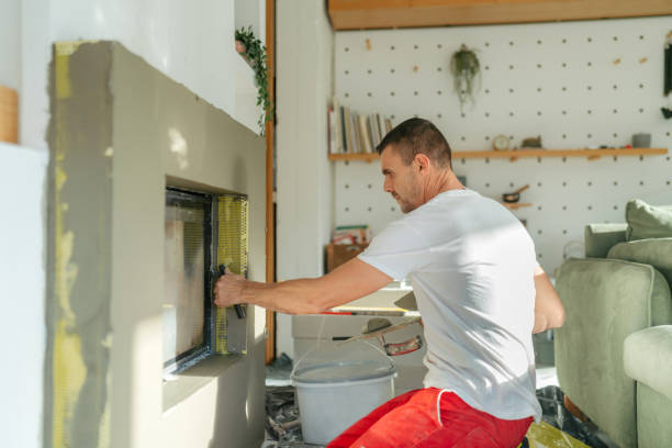 Plastering the fireplace Photo of a manual worker at construction site, plastering a fireplace drywall fireplace stock pictures, royalty-free photos & images