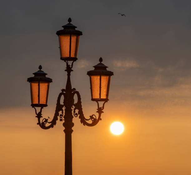 Close up of ancient lantern of Venice, Italy, is illuminated by the rising sun in the early morning.\nCanon EOS R5 II, 1/160, f/11, 105 mm.