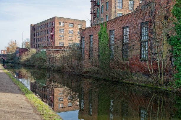istock Historic brick warehouse mill buildings reflected in a serene canal on a clear day. 2203086918