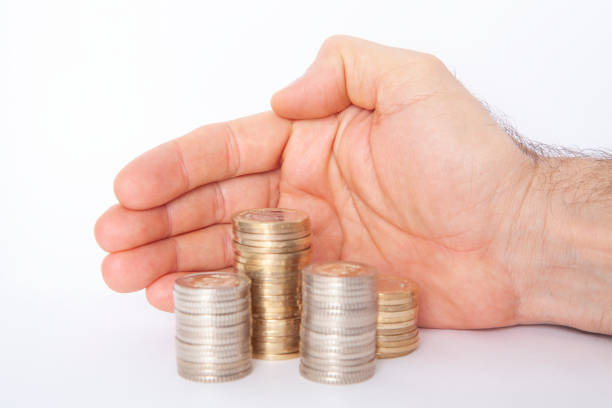 Cutout one palm of hand holding displaying or showing flat lay of stack or pile of many several Indian 10 ten rupee denomination golden currency coins money in gold color spread out isolated over white colored horizontal transparent backgrounds