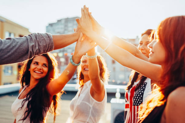 istock Group of friends celebrating with a High-Five on a rooftop party 2203089439
