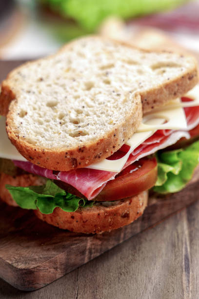 istock Whole grain bread sandwich with ham, tomato, cheese and lettuce 2203093198