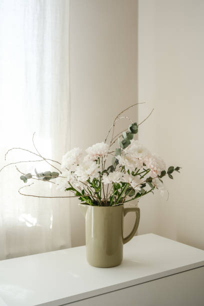 istock An elegant floral display in arranged beautifully in a minimalistic vase that sits gracefully on a white surface. 2203094154