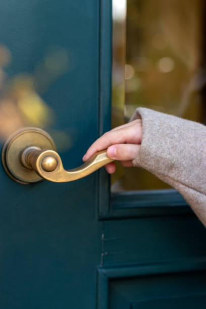 Child's hand holds the handle of door