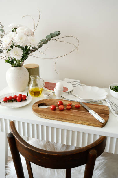 istock A beautifully arranged dining table with cutting board, fresh, vibrant ingredients - tomatoes, ham, aragula, fruits, olive oil, ready for cooking and meal preparation. 2203096030
